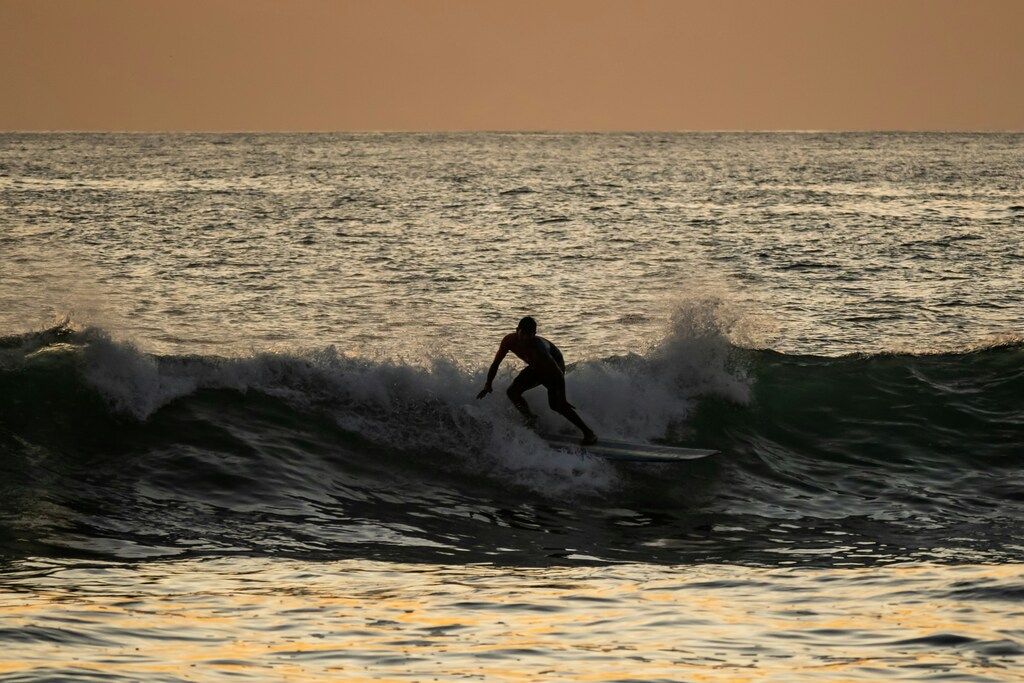 Ein Mann reitet auf einer Welle auf einem Surfbrett in Costa Rica