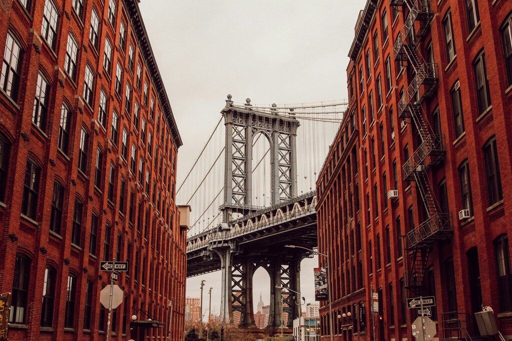 Die Manhattan Bridge zwischen roten Backsteingebäuden in DUMBO, Brooklyn, New York City.
