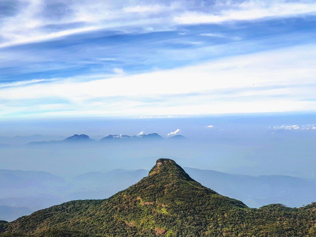 Grüner Berg unter weißen Wolken am Tag