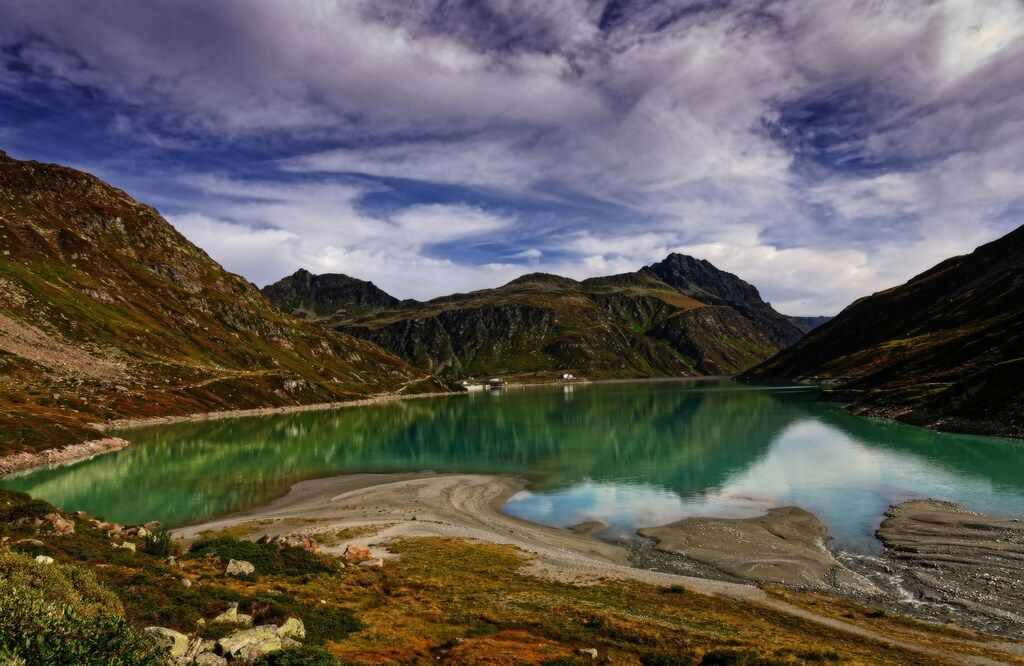 Alpiner Bergsee in den Silvretta Alpen, umgeben von Bergen und dramatischem Himmel: Alpenwanderung