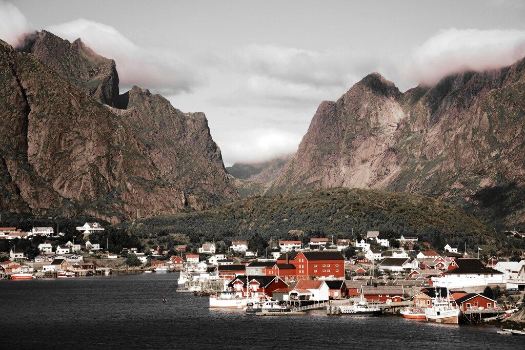 Lofoten Sehenswürdigkeiten: Ein malerisches Fischerdorf umgeben von majestätischen Bergen und ruhiger Küstenlandschaft.