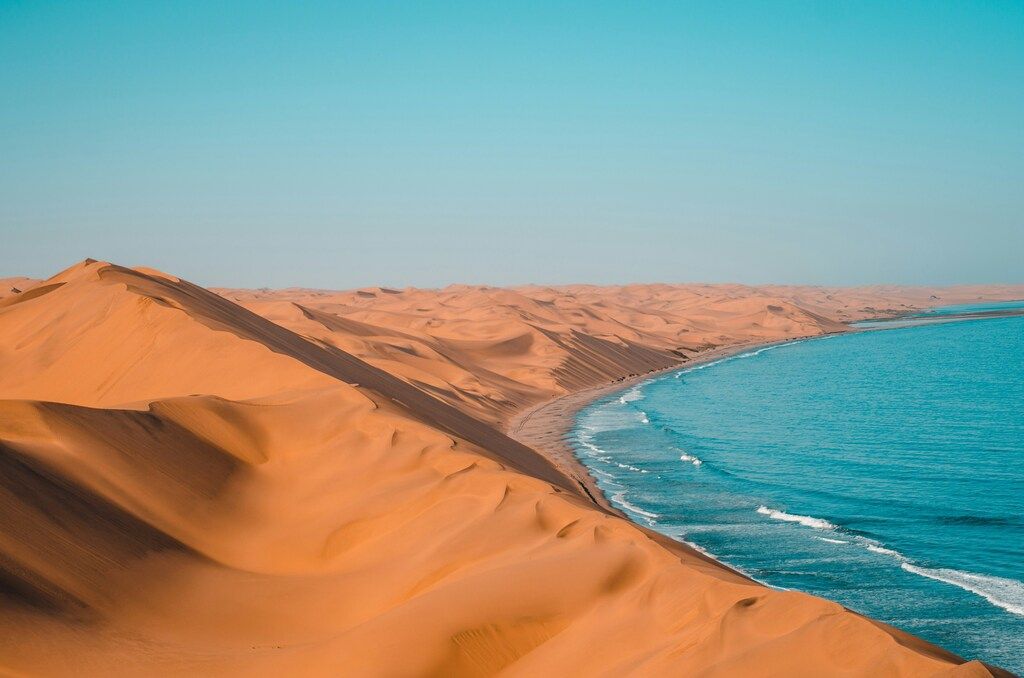 Küste mit Sanddünen, die bis ans Meer reichen