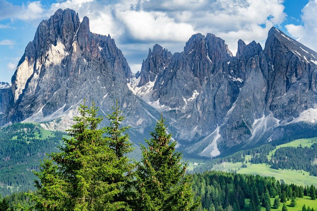 Majestätische Felsformationen der Dolomiten mit grünen Wäldern im Vordergrund: Alpenwanderung