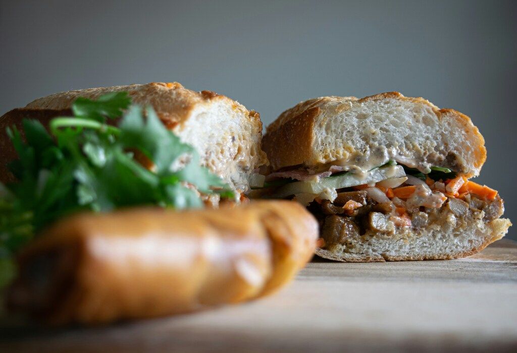 Vietnamesisches Essen: Brot mit grünem Gemüse auf braunem Holztisch