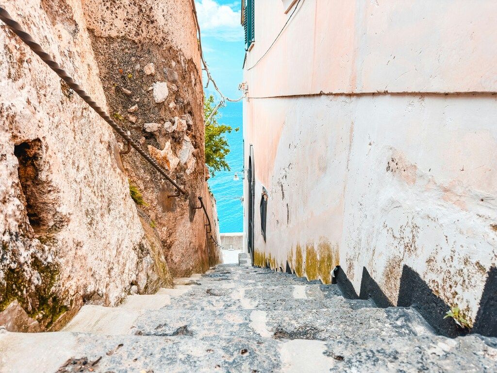 Enge Steintreppe mit Blick auf das blaue Meer an der Amalfiküste