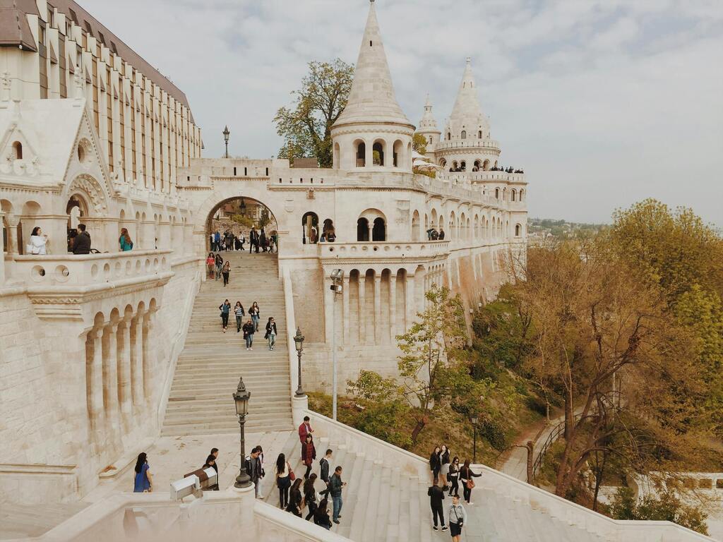 Der Fischerbastei in Budapest, ein historisches Bauwerk mit Treppen und Bögen, voller Besucher.