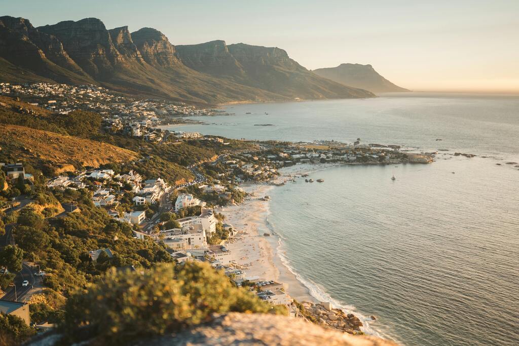 Bild von Camps Bay in Kapstadt bei Sonnenuntergang, mit Blick auf die Zwölf Apostel-Bergkette.