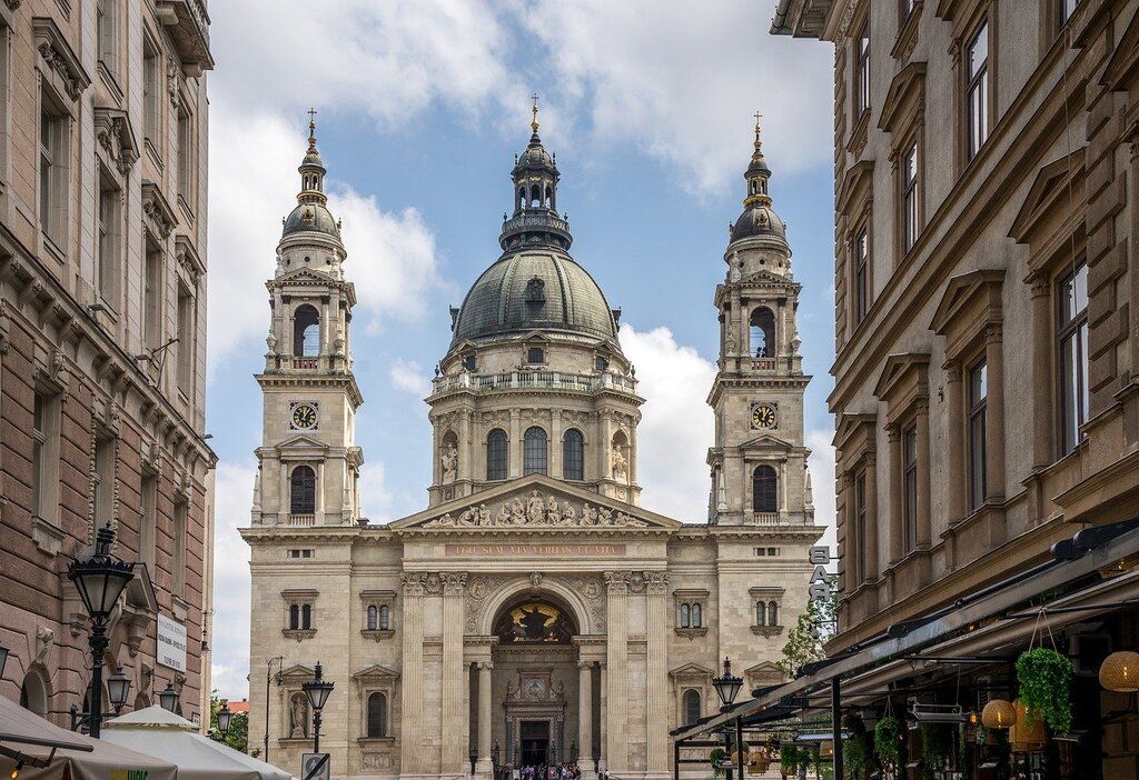 Die St.-Stephans-Basilika in Budapest, umgeben von historischen Gebäuden und Cafés.
