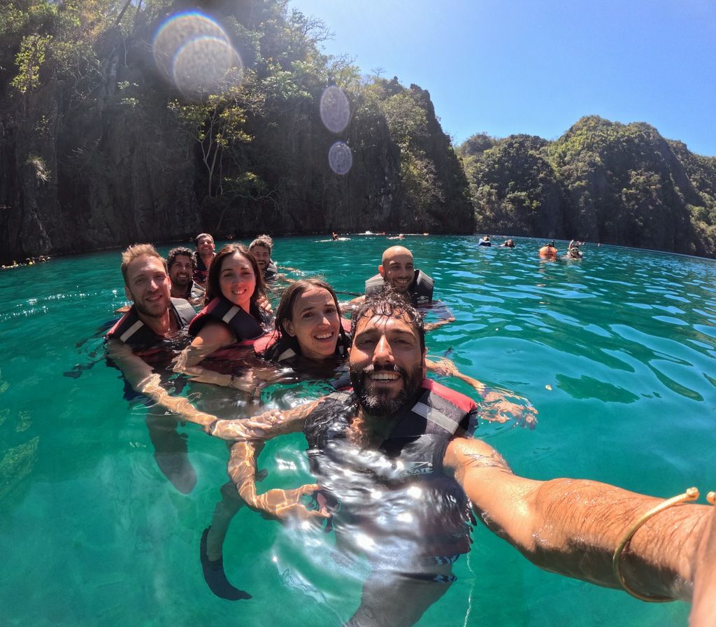 Gruppe auf einem WeRoad-trip schwimmend in türkisblauem wasser, umgeben von Coron-Felsen auf den Philippinen