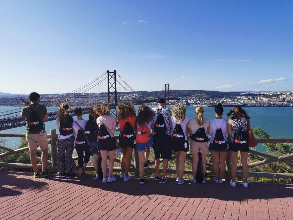 Reisegruppe von Weroad, die auf die Ponte 25 de Abril in Lissabon blickt, bei strahlend schönem Wetter.