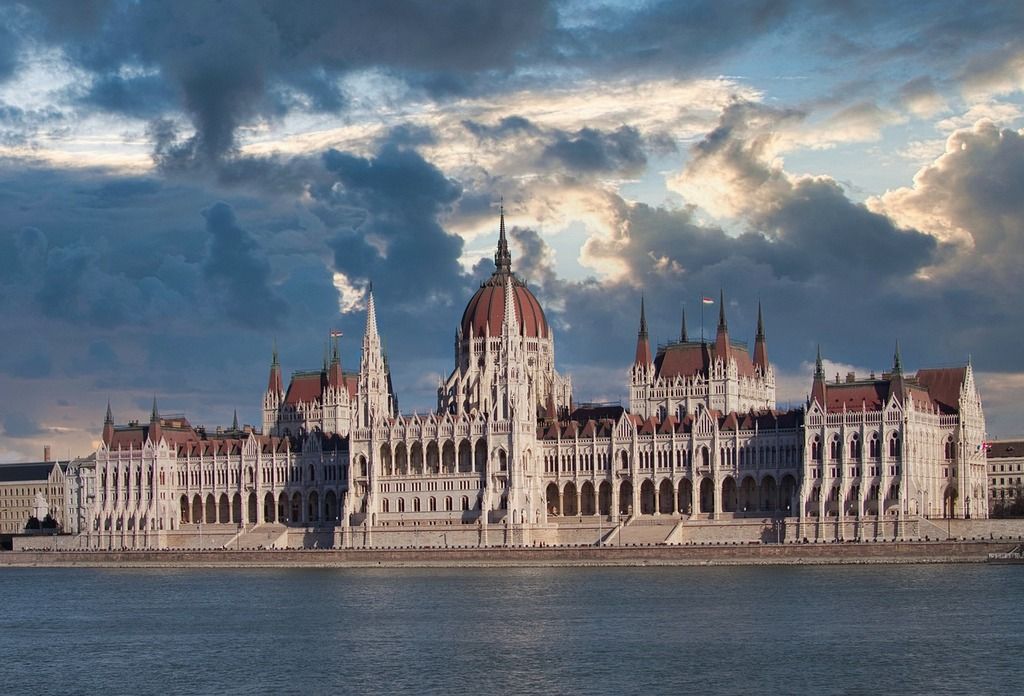 Bild des ungarischen Parlamentsgebäudes in Budapest mit dramatischem Himmel im Hintergrund.