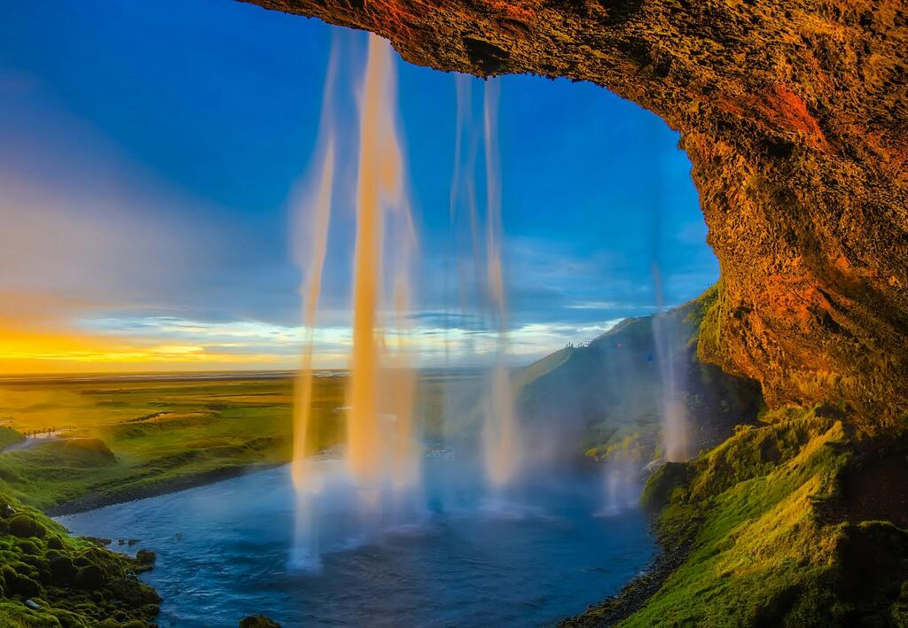 Ein beeindruckender Blick hinter den Seljalandsfoss-Wasserfall bei Sonnenuntergang in Island.