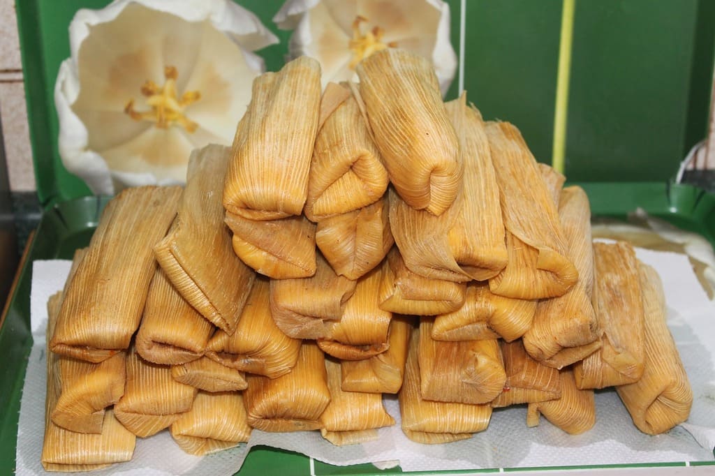 Ein Stapel traditioneller Tamales, umgeben von Dekoration.