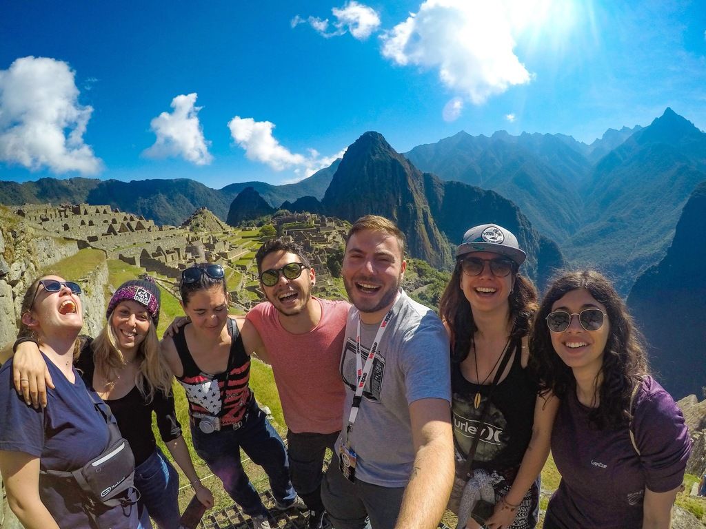 Eine WeRoad-Gruppe genießt den Ausblick auf Machu Picchu während einer Gruppenreise in Peru.