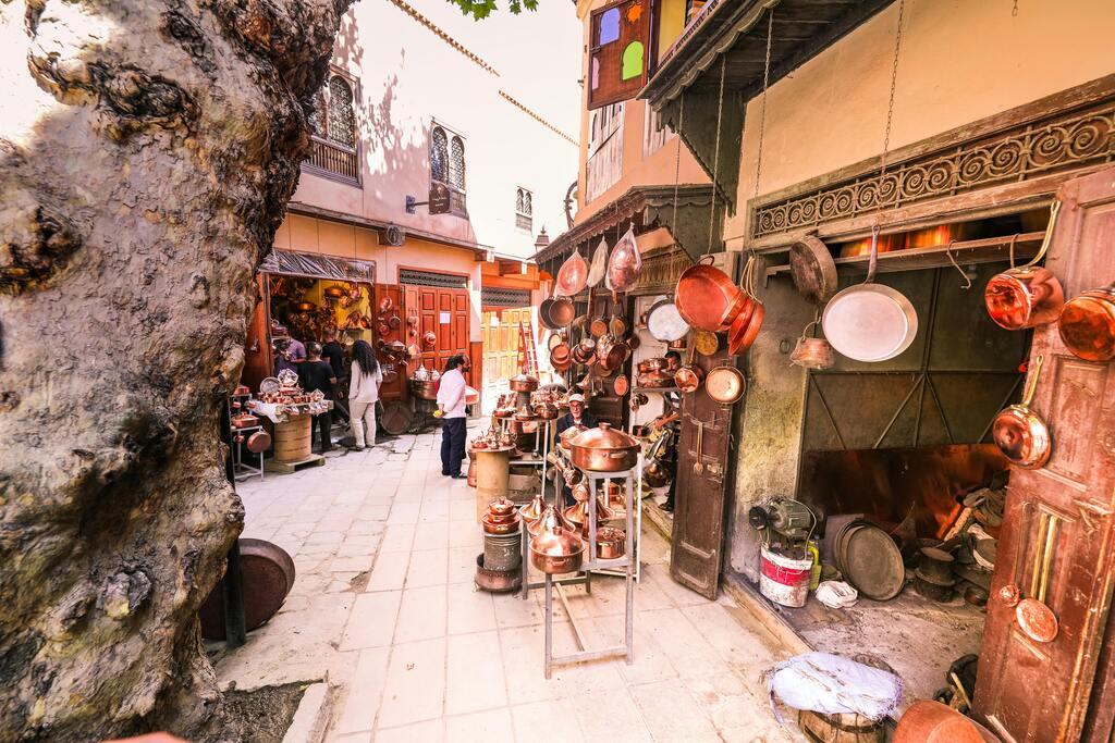 Traditionelle Kupferschmiede im Souk von Marrakesch mit handgefertigten Töpfen und Pfannen.