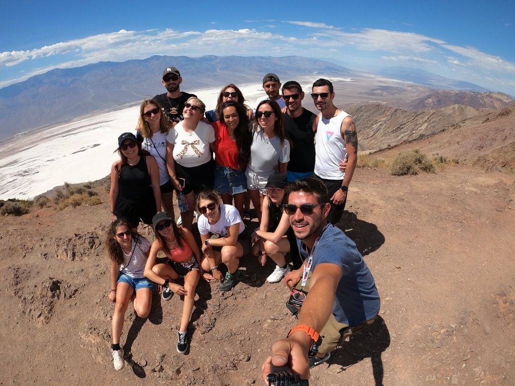 Eine WeRoad-Reisegruppe beim Wandern in einer spektakulären Landschaft Kanadas, die gemeinsam ein Selfie macht.
