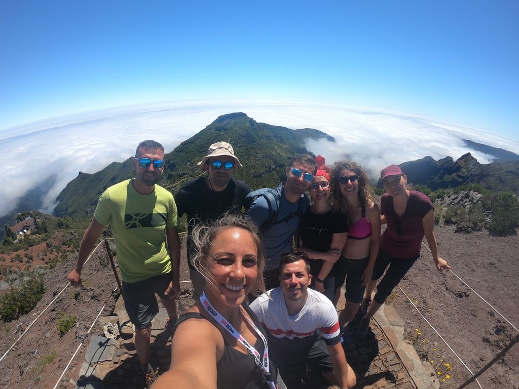 WeRoad-Reisegruppe auf einer Wanderung in Madeira, umgeben von Bergen und einer spektakulären Aussicht.