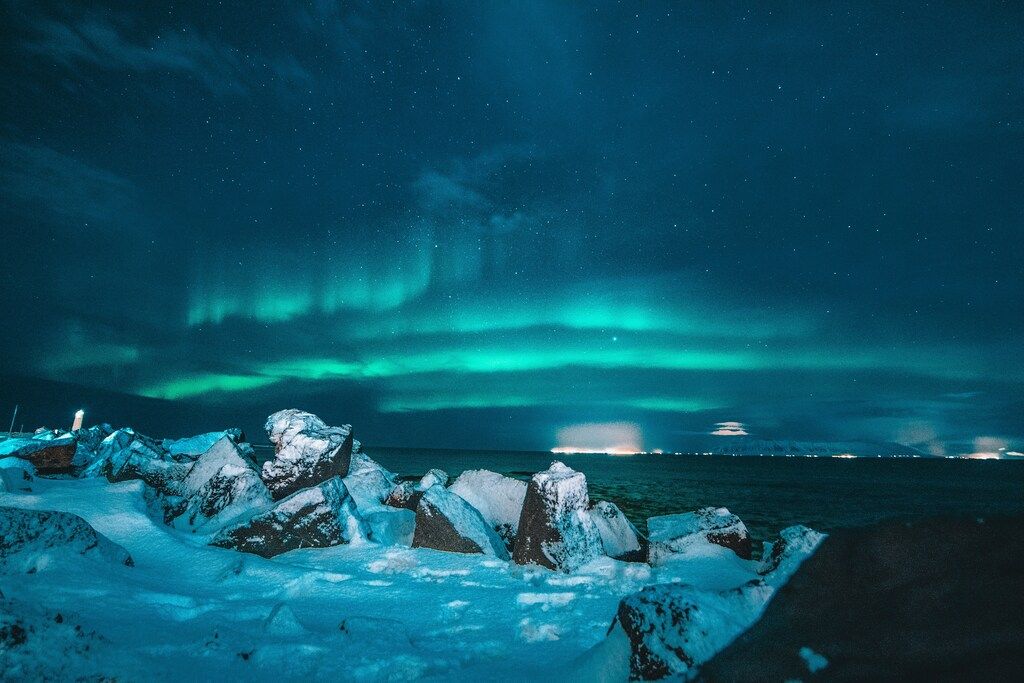 Nordlichter über einer verschneiten Küste in der Nacht
