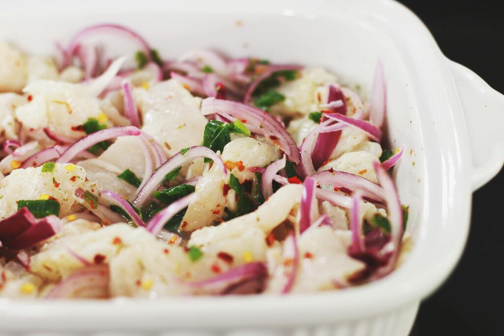 Ceviche mit roten Zwiebeln, Chili und Koriander in einer weißen Schale