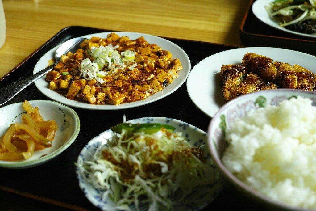 Typisches Gericht der Hunan-Küche mit scharfem Tofu, gebratenem Fleisch, Reis und Beilagen.