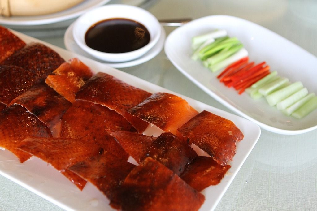 Peking-Ente mit Sojasauce, Gurken- und Karottenstreifen.