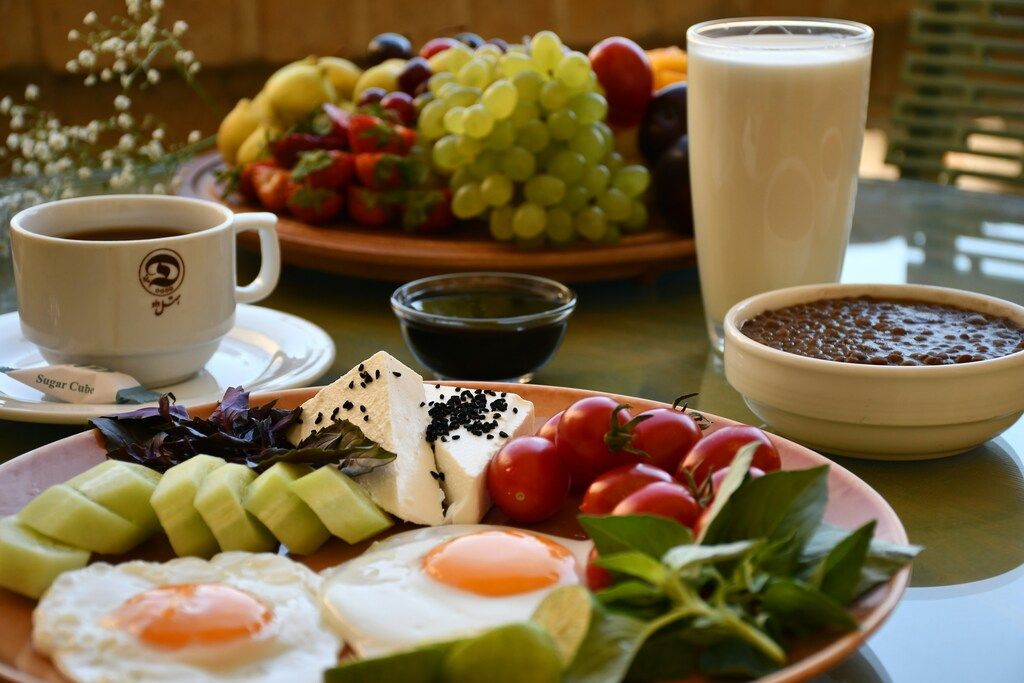 Traditionelles Frühstück mit Eiern, Gemüse, Käse und Getränken