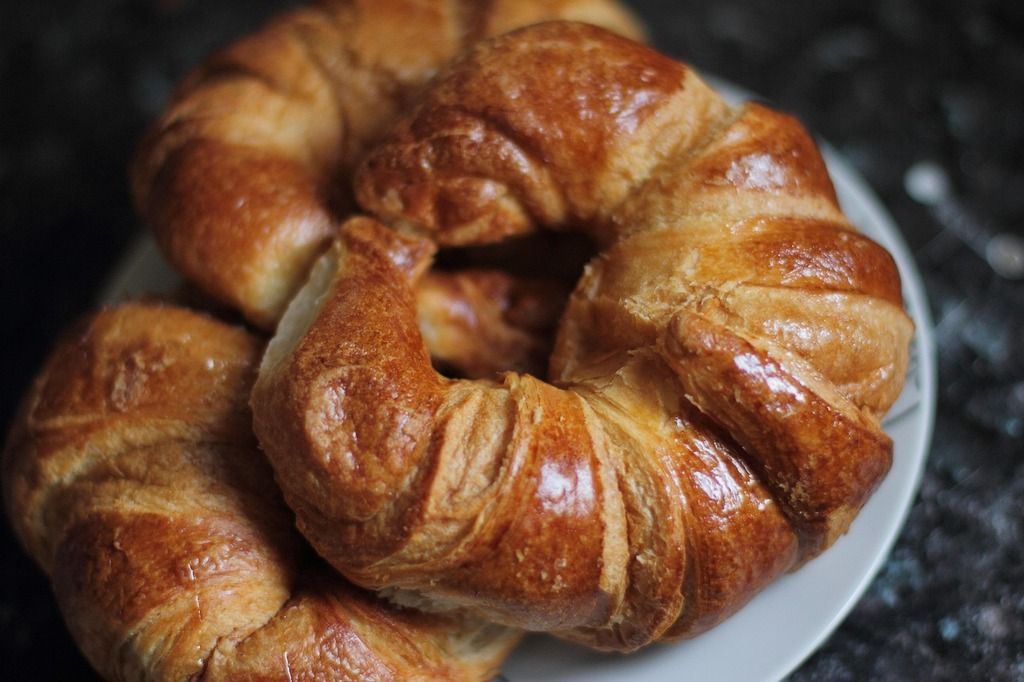 Stapel goldbrauner französischer Croissants auf einem Teller.