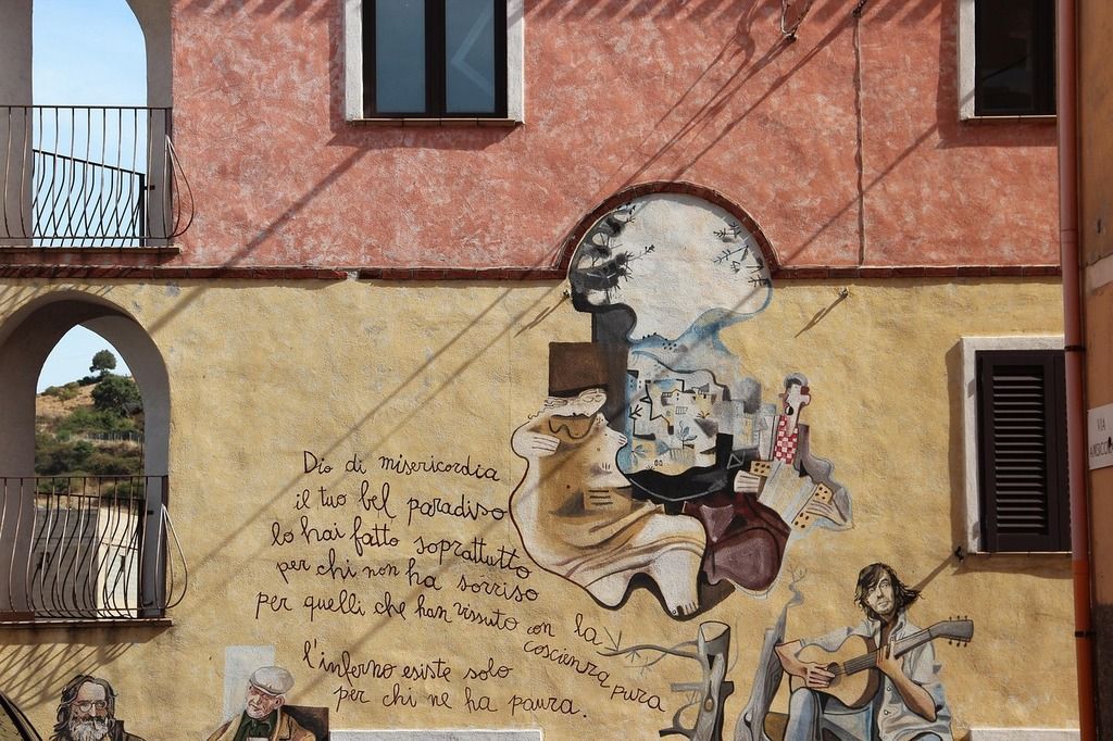 Wandgemälde in einer Gasse von Orgosolo auf Sardinien mit Text.