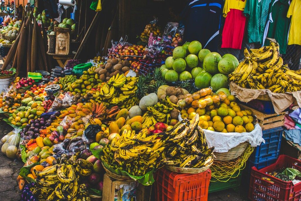 Bunter Obstmarkt mit Bananen, Papayas, Mangos und anderen tropischen Früchten.