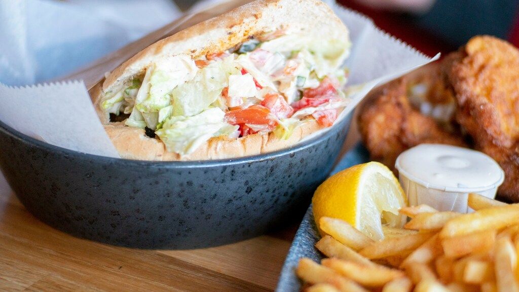 Frisches Pita-Sandwich mit Salatfüllung, serviert mit Pommes und Zitrone