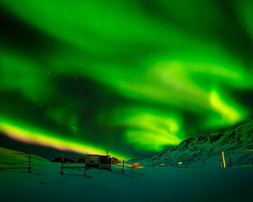 Spektakuläres Nordlicht am verschneiten arktischen Himmel