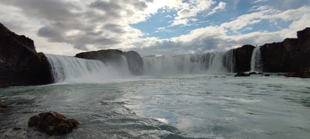 Breiter Gullfoss Wasserfall in Island mit gewaltigem Wasserstrom unter bewölktem Himmel.