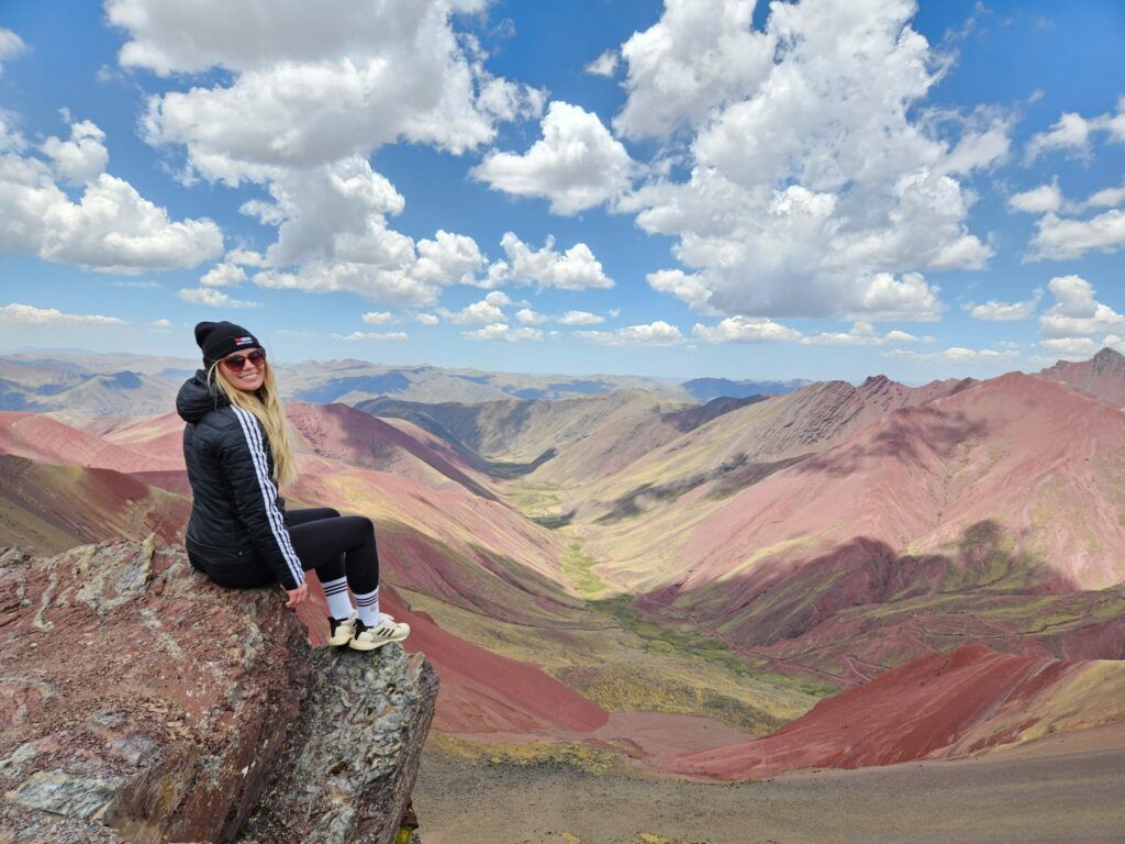 Frau genießt die Aussicht auf die rote Landschaft in Palccoyo.
