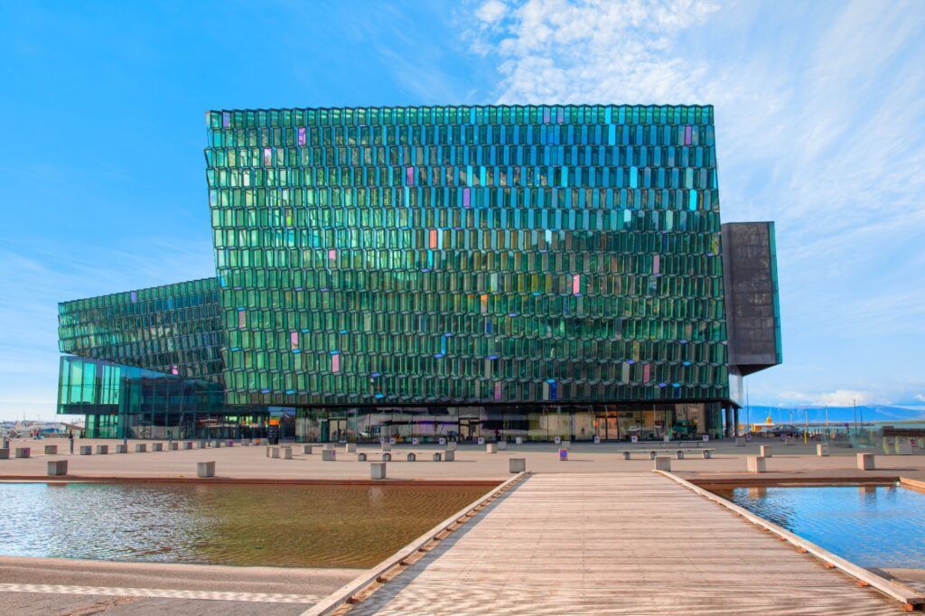 Die Harpa Konzerthalle in Reykjavik: Futuristische Fassade aus farbig reflektierenden Glasplatten am Hafen.